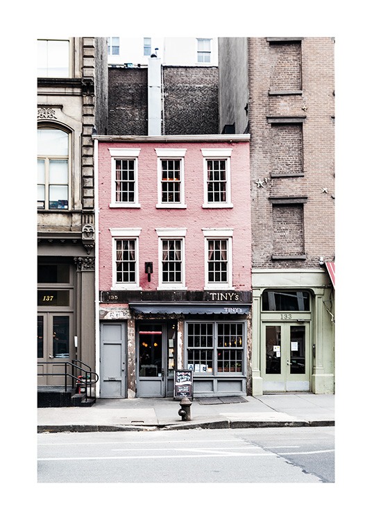  - Photo poster rich in contrast with a pink little house between two large buildings in New York.