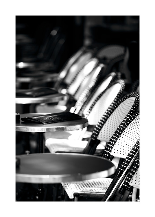  - Poster in black and white with the sun shining on the outdoor area of a Paris café.