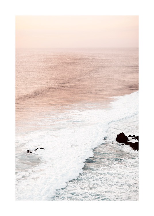  – Photograph of waves and a pink ocean with a light pink sky behind it
