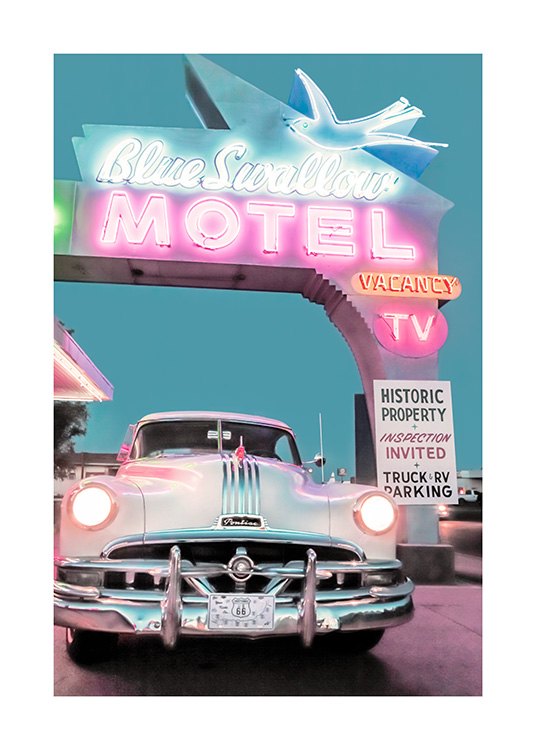Photograph of a vintage car in front of a large neon sign