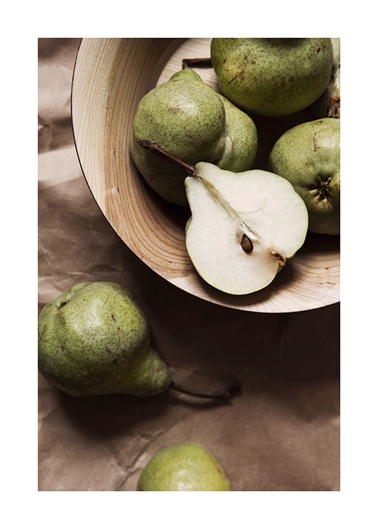 Green pears in a light brown wooden bowl