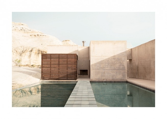 – Photograph of concrete building with mountains in the background and pool in front