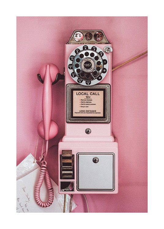 - Photograph of a pink pay phone with a retro style, on a pink background
