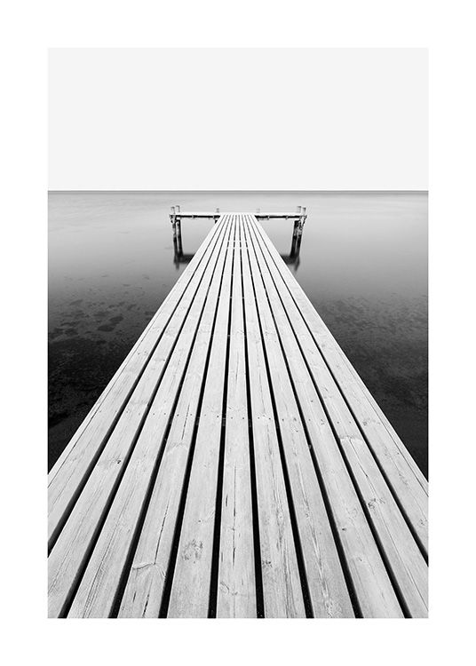  – Black and white photograph of an ocean with a jetty leading into the water