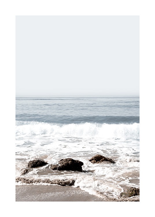  – Photograph of waves crashing up onto a beach with rocks