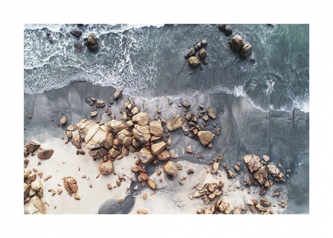  – Photograph from above of a seashore with rocks and boulders on the beach