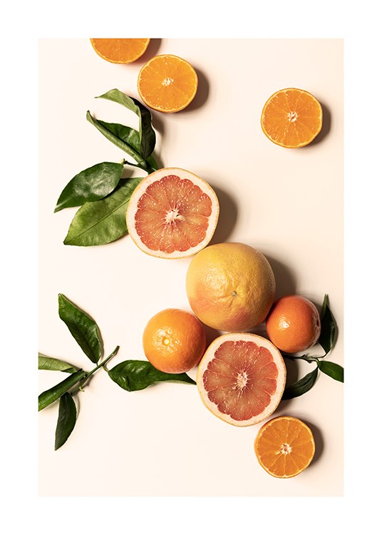  – Photograph of clementines, oranges and green leaves laying on a light yellow background
