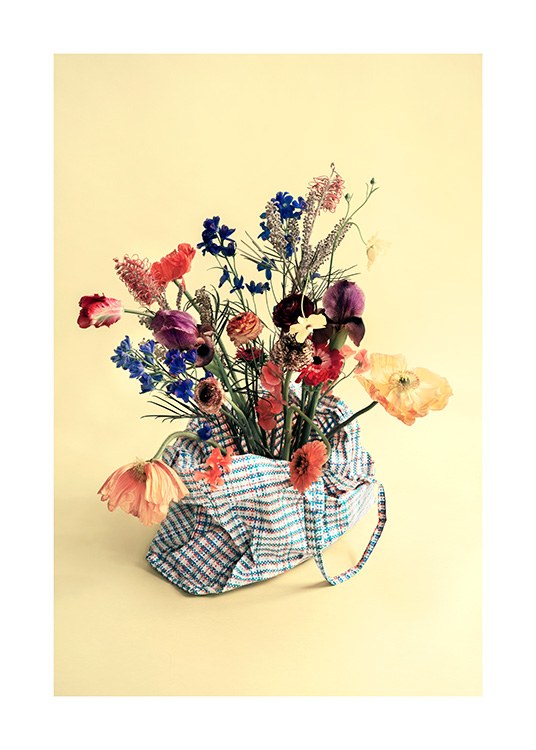  – Photograph of a bunch of colourful flowers in a tote bag against a yellow background