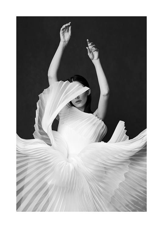 – Black and white photograph of a woman wearing a pleated, white dress, streching her arms up
