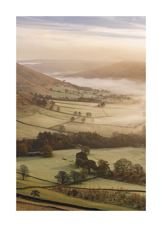  – Photograph of green fields, trees and hills covered in fog