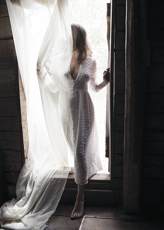  – Photograph of a woman sin a doorway in a white dress, covered by a white curtain