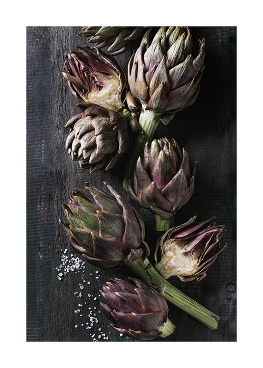  – Photograph of artichokes laying on a black, wooden table with some salt