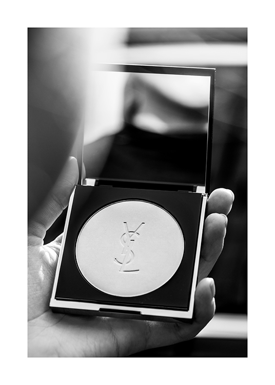  – Black and white photograph of someone holding a YSL powder with a mirror