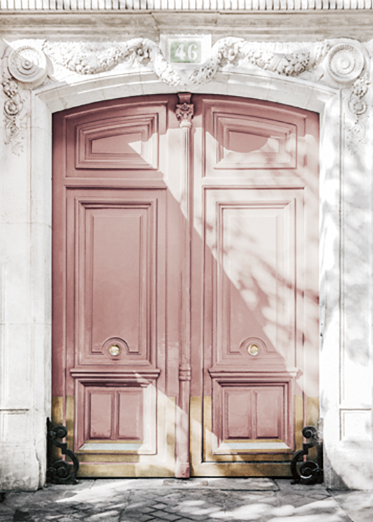  – Photograph of a large door in pink with gold details in a white building with carvings