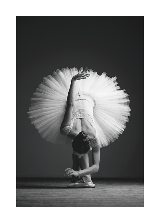  – Black and white photograph of a ballerina bending over forward in a tulle skirt