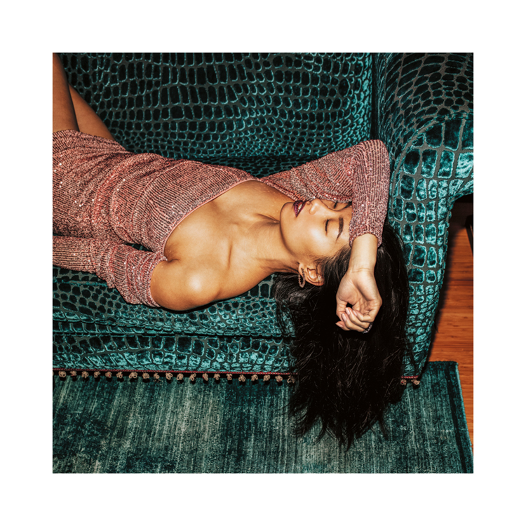  – A photograph of a woman in a sparkly dress taking a nap on a turquoise sofa