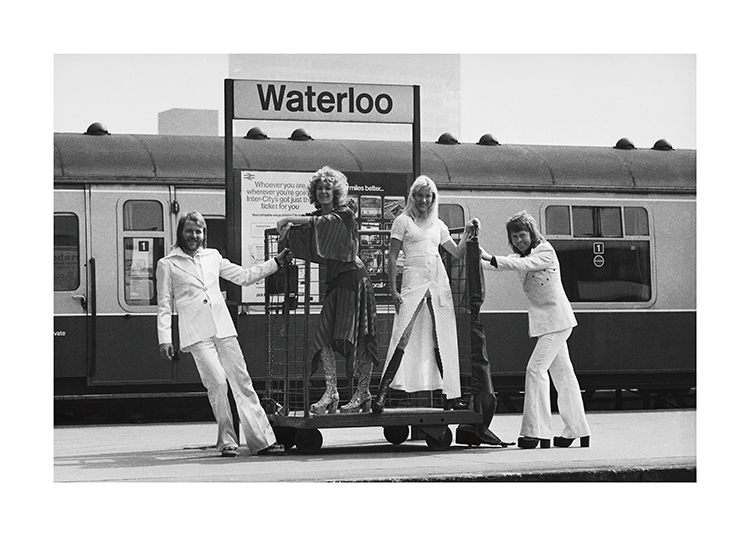  – Black and white photograph of the members of ABBA standing at the Waterloo train station