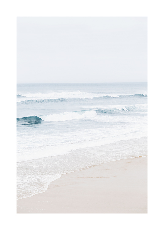  – Photograph of an ocean with blue water and soft waves, with a beach in front of it