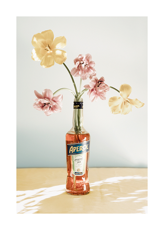 – Photograph of flowers in pink and yellow standing in a bottle of aperol