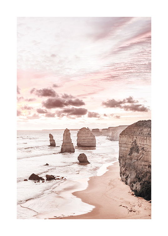  – Photograph of cliffs in and next to the ocean with a pastel pink sky behind the cliffs