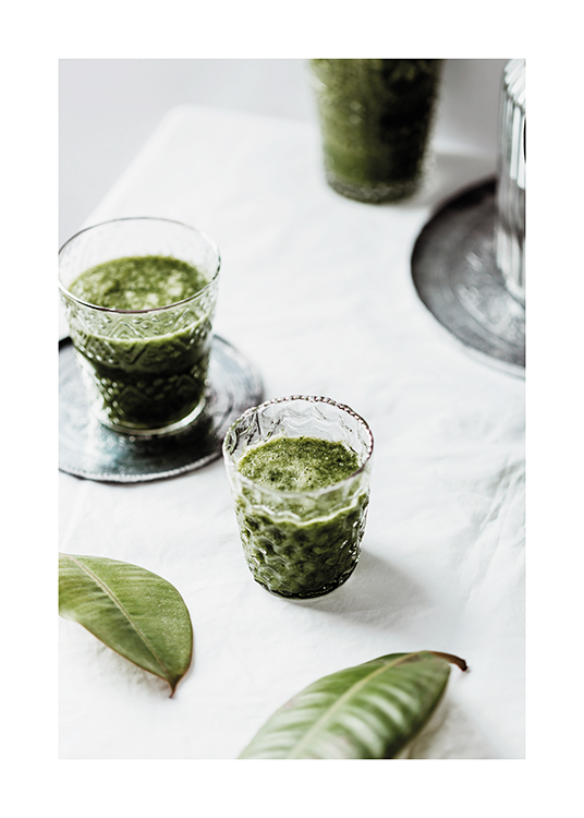  – Photograph of green leaves and glasses with green drinks against a white background