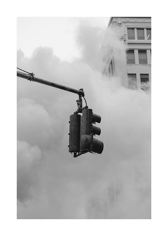  – Black and white photograph of a traffic light in front of a building and thick fog