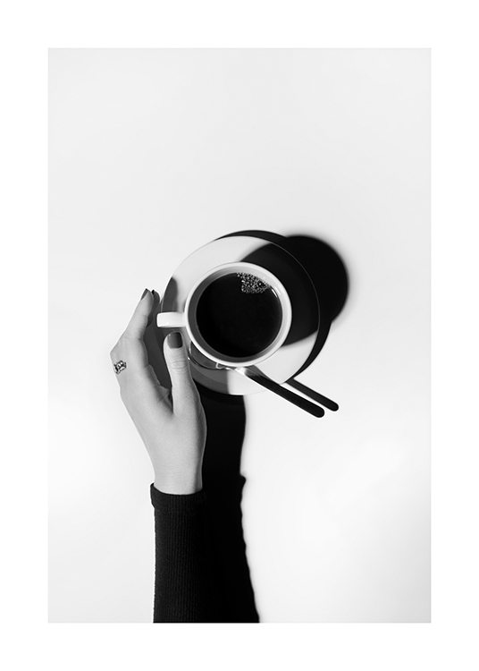 – Black and white photograph with a coffee cup in the middle and a hand reaching out for it