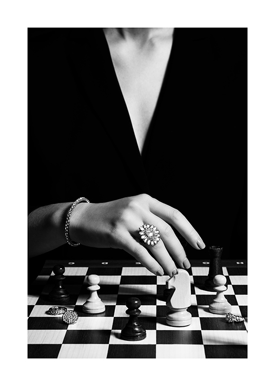 – Black and white photograph of a woman playing chess with a large ring on her finger
