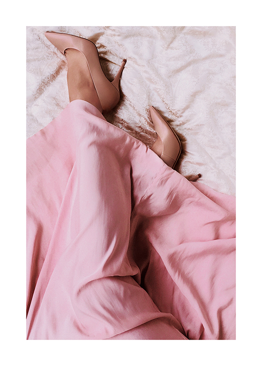 – Photograph of a woman with beige heels and a pink silk dress draped across her legs