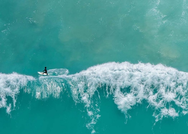  - Beautiful poster with a shot of a surfer in turquoise water from the air