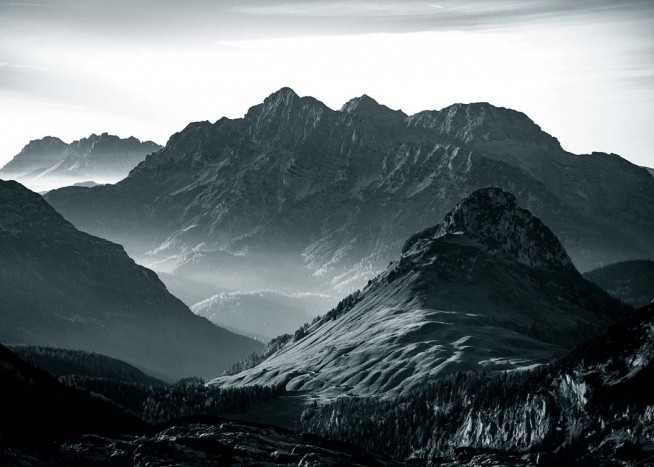  - Black and white nature photo of an alpine mountain range partially covered in snow.