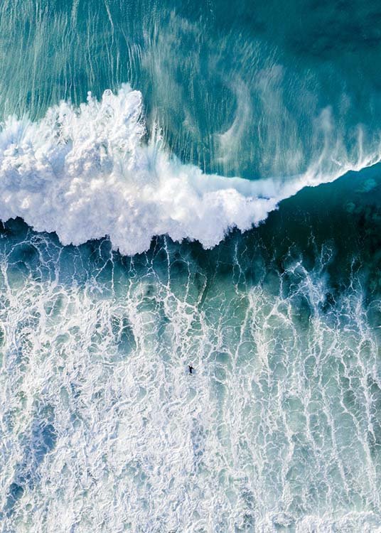  – Photograph from above of an ocean with large wave coming towards a surfer