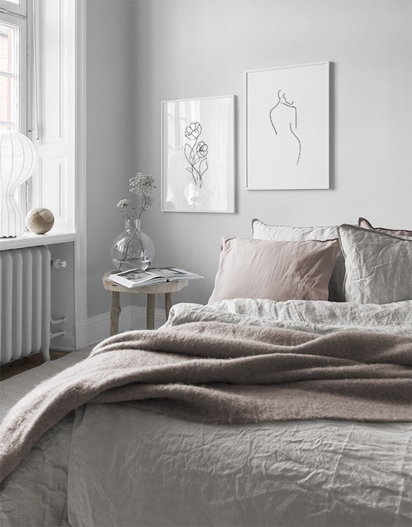 Romantic style bedroom with pale pink tones and minimalist posters